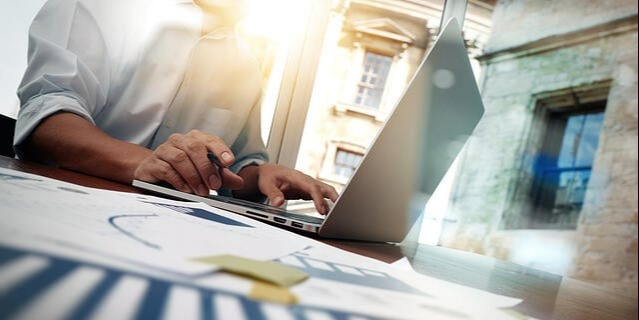business documents on office table with smart phone and digital tablet and graph financial diagram and man working in the background-1-1